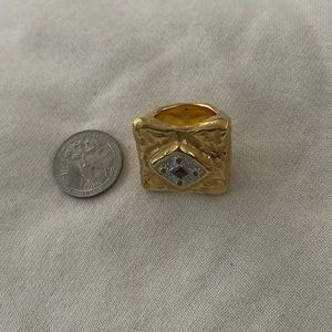18kt yellow gold with little red tourmaline on top. It’s a show off ring